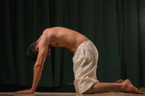 On hands and knees with the back arched high and the head tucked in.