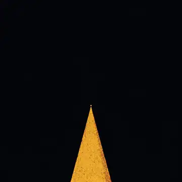 A narrow path of light across a dark plain, running to one point on the horizon.
